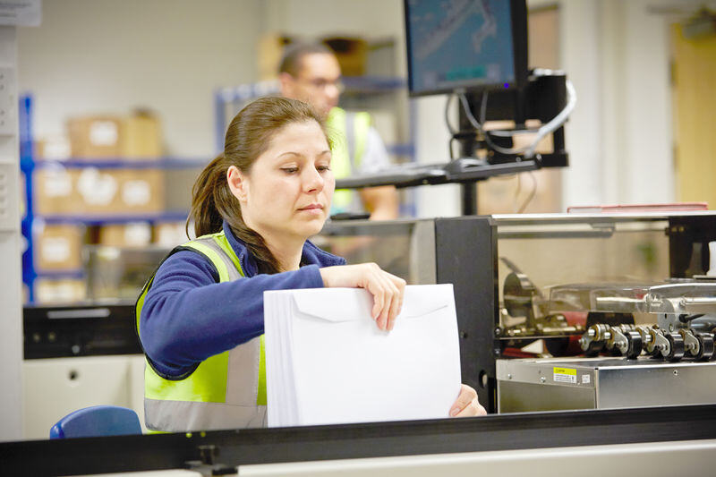 Mujer operando maquinaria de impresión en una planta de producción, Asendia